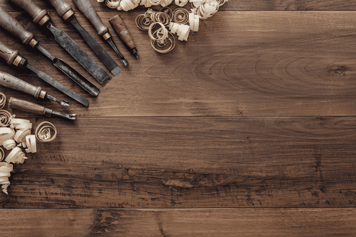 Carpentry tools and wood shavings on a dark timber surface